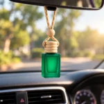 green car perfume bottle hanging from car rear view mirror with braided rope